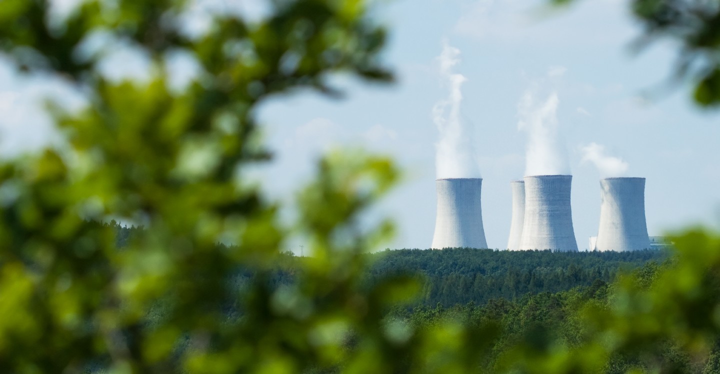 A landscape picture of a nuclear plant off in the distance.